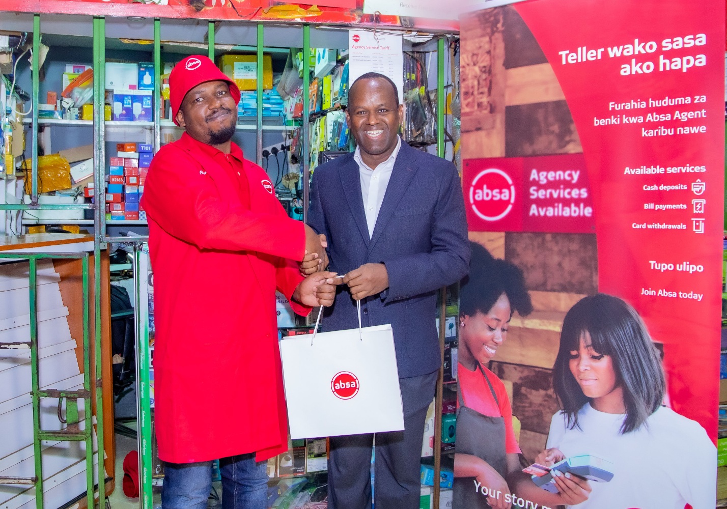 Absa Bank Kenya MD and CEO Abdi Mohamed presents a gift to Absa Bank Ruaka agent Sammy Njoroge during the launch of Absa Bank agency banking expansion drive. The bank is targeting to expand its agency banking network to 17,000 outlets within the next two years. PHOTO/COURTESY