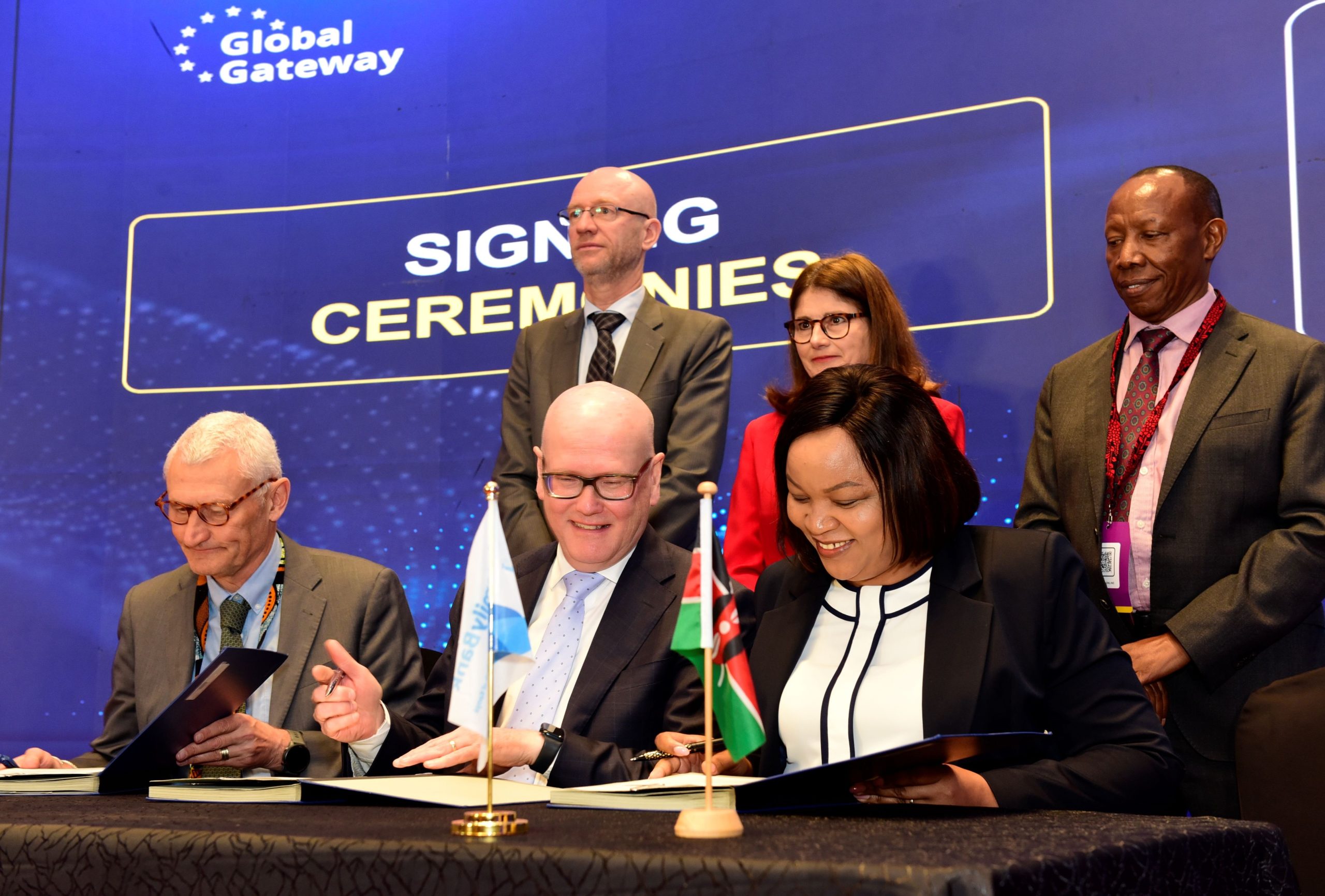  Family Bank CEO Nancy Njau(R), European Investment Bank (EIB) Vice President Thomas Ostros (C) & Director for African International Partnerships at the European Commission Hans Christian Stausboll sign a partnership mobilising KES. 14.7 billion to expand credit access for women-owned/led enterprises and youth entrepreneurs with each institution contributing half of the total funding. Looking on is Head of the EIB Regional Hub for EA Edward Classen, EU Ambassador to Kenya H.E. Henriette Geiger and Family Bank Chair Lazarus Muema.